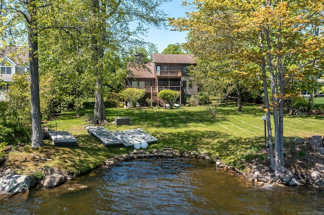 rear view of property featuring a lawn, stairs, a chimney, and a balcony