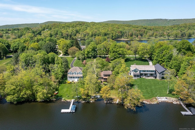 drone / aerial view of a heavily wooded area and a large body of water