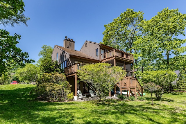 back of property featuring a chimney, a lawn, stairway, a balcony, and a sunroom