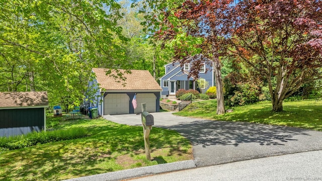 12 Sandy Ln, Marlborough, CT 06447 - view of front facade featuring a garage, a front lawn, an outdoor structure, and asphalt driveway