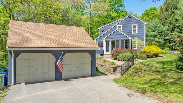 12 Sandy Ln, Marlborough, CT 06447 - view of front of house featuring roof with shingles, a garage, and a front yard