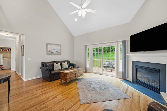 107 Chestnut Hill Rd Unit 107, Portland, CT 06480 - living area with high vaulted ceiling, independent washer and dryer, light wood-style flooring, ceiling fan, and a fireplace with flush hearth