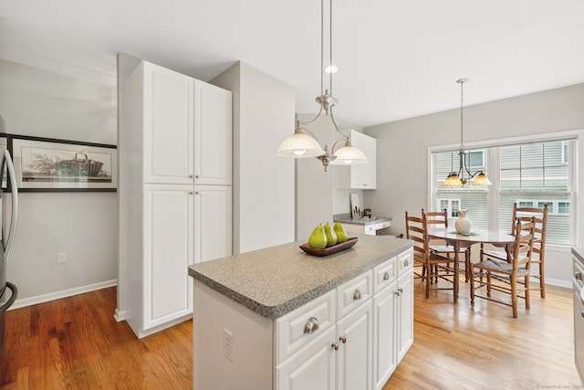 107 Chestnut Hill Rd Unit 107, Portland, CT 06480 - kitchen featuring light wood finished floors, white cabinetry, a center island, and decorative light fixtures