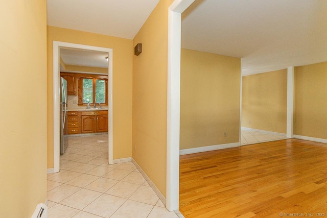 123 Jeffrey Ln, Newington, CT 06111 - hallway with a sink, light wood-style flooring, and baseboards