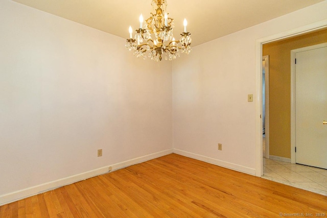 123 Jeffrey Ln, Newington, CT 06111 - spare room with a chandelier, light wood-style flooring, and baseboards