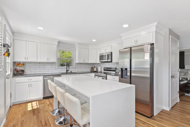 26 Carroll Rd, Hamden, CT 06517 - kitchen with stainless steel appliances, a sink, decorative backsplash, light wood-type flooring, and recessed lighting