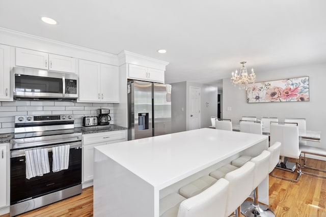 26 Carroll Rd, Hamden, CT 06517 - kitchen featuring stainless steel appliances, a chandelier, light wood finished floors, white cabinetry, and recessed lighting