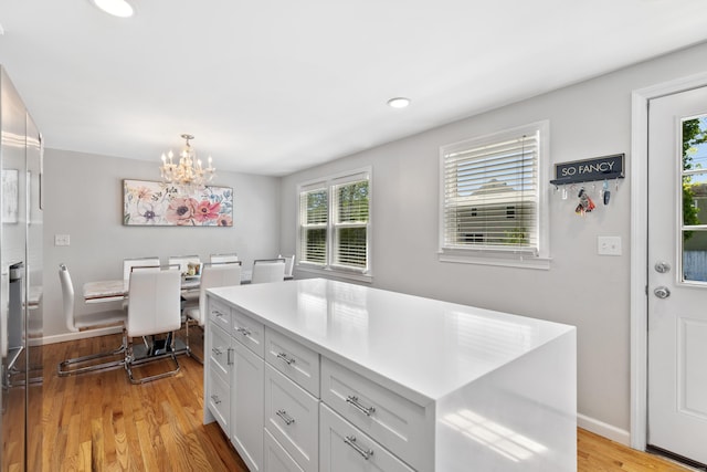 26 Carroll Rd, Hamden, CT 06517 - kitchen featuring a chandelier, light wood-style floors, white cabinetry, light countertops, and baseboards
