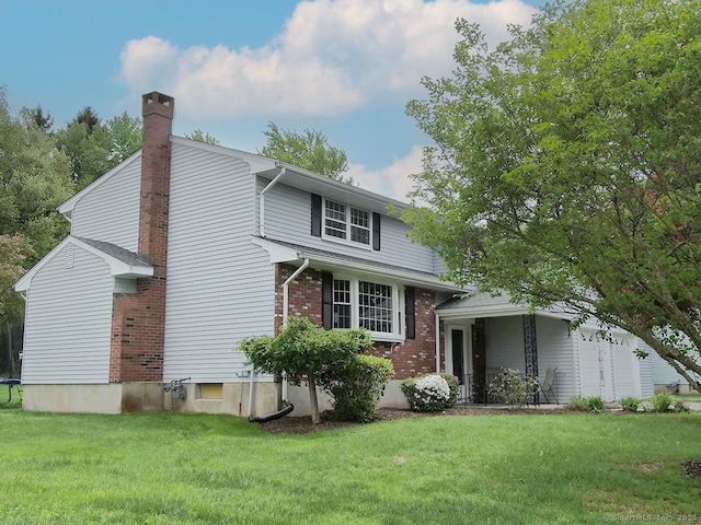 207 Pheasant Dr, Rocky Hill, CT 06067 - view of front of home with a front yard, brick siding, and a chimney
