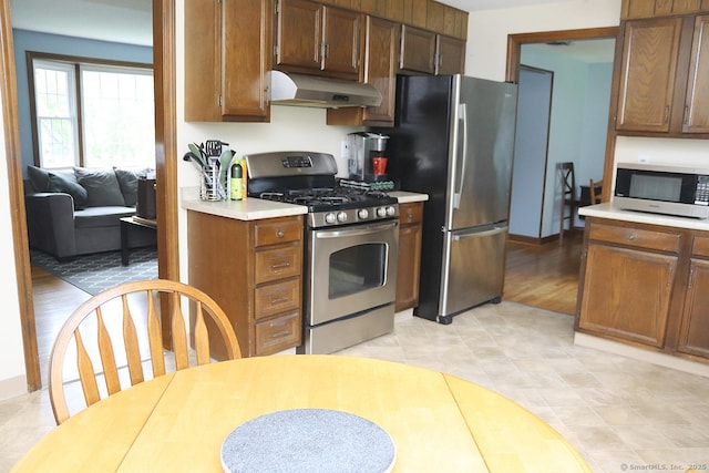 207 Pheasant Dr, Rocky Hill, CT 06067 - kitchen with under cabinet range hood, appliances with stainless steel finishes, and light countertops