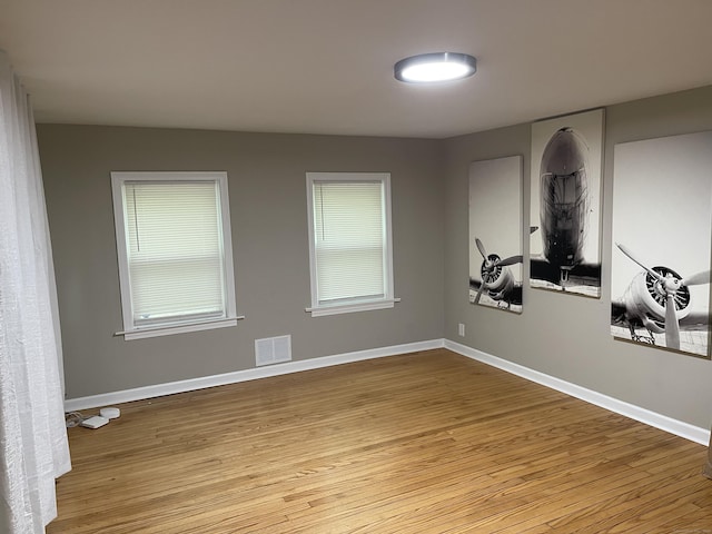 spare room with light wood-style floors, baseboards, and healthy amount of natural light