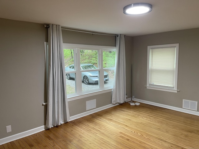 spare room featuring light wood-style flooring and baseboards