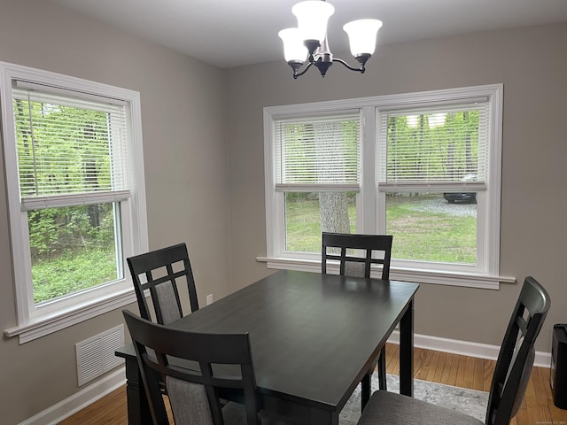 dining area with a chandelier, baseboards, and wood finished floors
