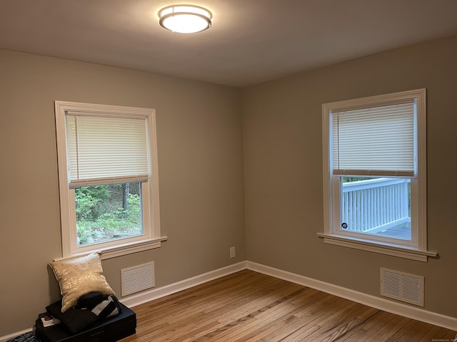 unfurnished room featuring hardwood / wood-style floors and baseboards