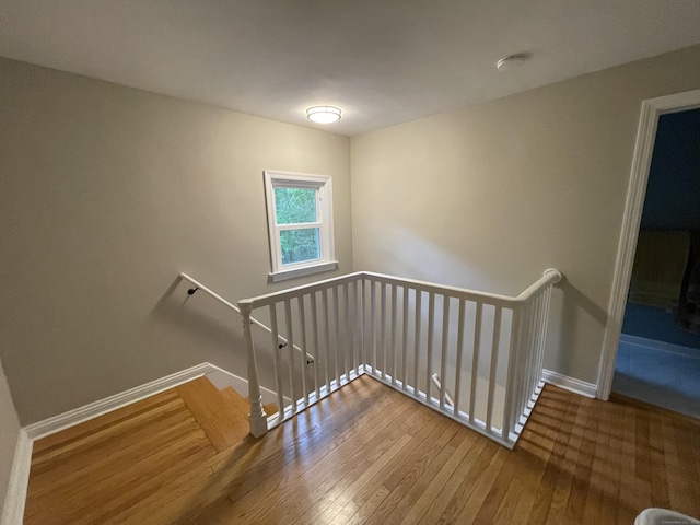 staircase featuring wood-type flooring and baseboards