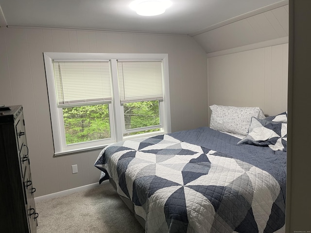 bedroom with light colored carpet, vaulted ceiling, and baseboards