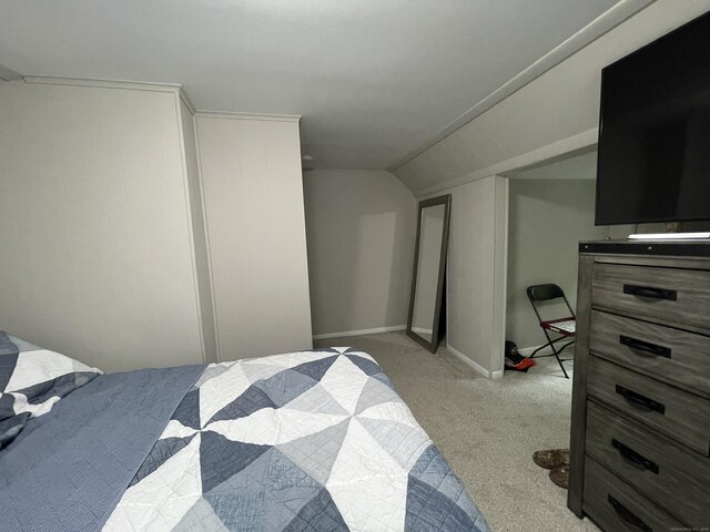 bedroom featuring light colored carpet and vaulted ceiling