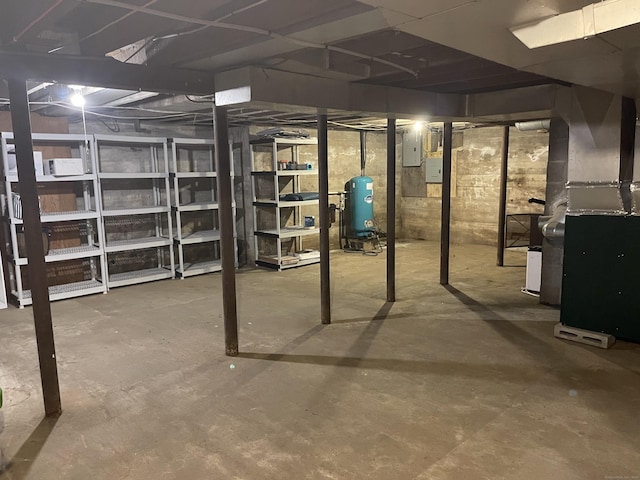 unfinished below grade area with a water pressure tank, heating unit, and electric panel
