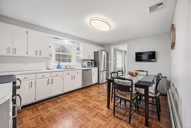 91 Parklawn Dr, Waterbury, CT 06708 - kitchen featuring appliances with stainless steel finishes, light countertops, baseboard heating, white cabinetry, and a sink