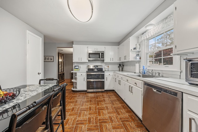 91 Parklawn Dr, Waterbury, CT 06708 - kitchen with stainless steel appliances, a sink, open shelves, brick patterned floors, and light countertops