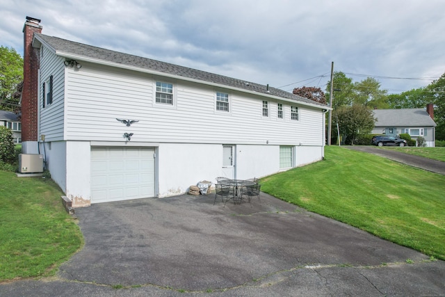 91 Parklawn Dr, Waterbury, CT 06708 - rear view of property featuring a chimney, a garage, a yard, and driveway