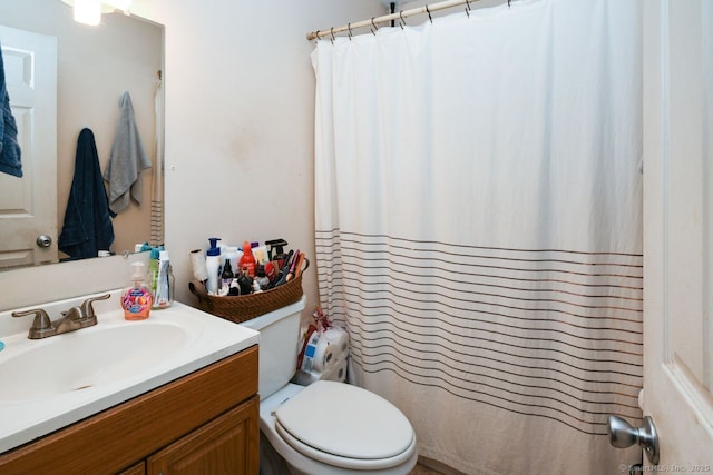 bathroom featuring vanity, toilet, and curtained shower