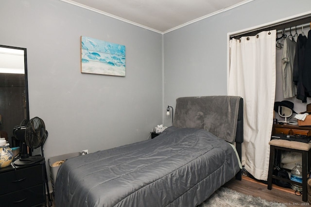 bedroom with ornamental molding and wood finished floors