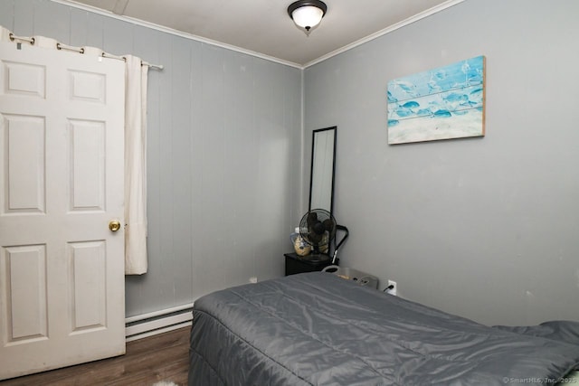 bedroom featuring a baseboard heating unit, dark wood-style flooring, and ornamental molding