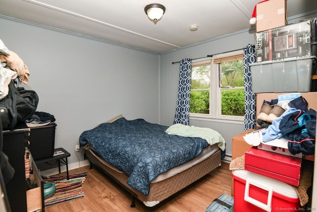 bedroom with wood finished floors and a baseboard radiator