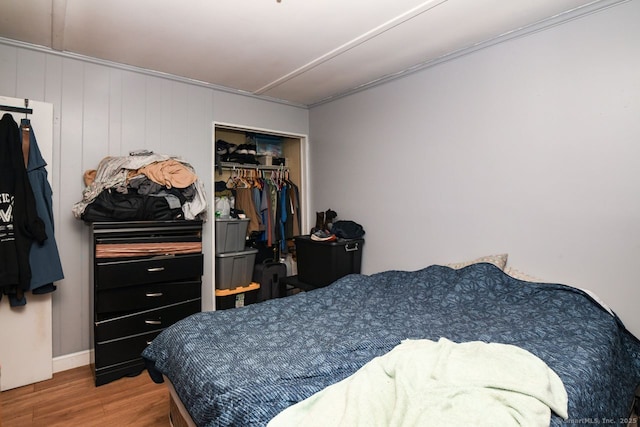 bedroom with wood finished floors and a closet
