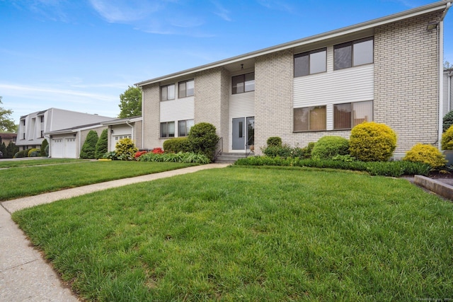 61 Riverside Ave Unit 15, Stamford, CT 06905 - view of front facade with brick siding, a garage, and a front lawn