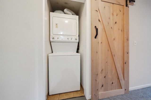61 Riverside Ave Unit 15, Stamford, CT 06905 - laundry area with stacked washer / dryer, a barn door, and baseboards