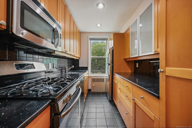 7 4th St Unit 1C, Stamford, CT 06905 - kitchen featuring appliances with stainless steel finishes, radiator heating unit, a sink, tile patterned flooring, and backsplash