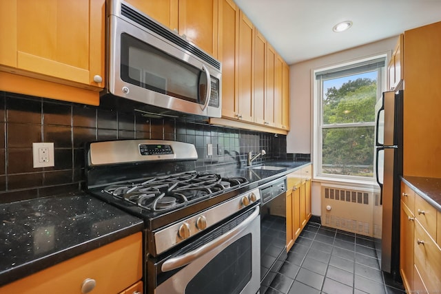 7 4th St Unit 1C, Stamford, CT 06905 - kitchen featuring appliances with stainless steel finishes, radiator heating unit, a sink, tile patterned flooring, and decorative backsplash