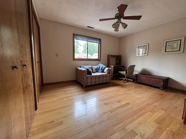 227 Twin Lakes Rd Apt C, North Branford, CT 06471 - sitting room featuring light wood-style floors, a ceiling fan, a textured ceiling, and baseboards