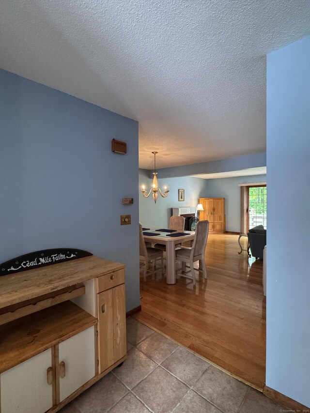 227 Twin Lakes Rd Apt C, North Branford, CT 06471 - tiled dining area with a textured ceiling, a chandelier, and baseboards