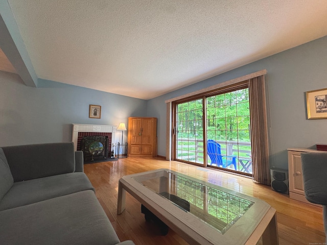 227 Twin Lakes Rd Apt C, North Branford, CT 06471 - living room featuring a textured ceiling, light wood finished floors, and a fireplace