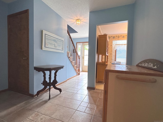 227 Twin Lakes Rd Apt C, North Branford, CT 06471 - foyer with stairway, a textured ceiling, baseboards, and light tile patterned flooring