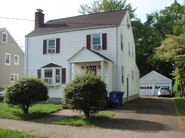 566 Savoy St, Bridgeport, CT 06606 - view of front facade with a chimney, an outbuilding, a detached garage, cooling unit, and a shingled roof