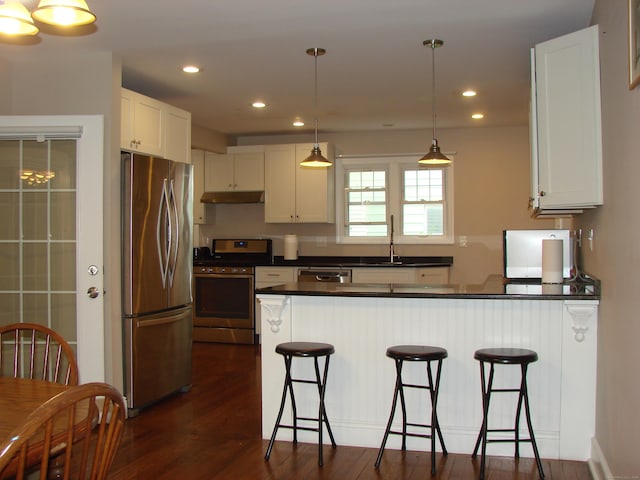 566 Savoy St, Bridgeport, CT 06606 - kitchen with stainless steel appliances, under cabinet range hood, a peninsula, dark countertops, and white cabinets