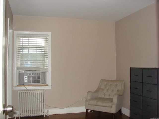 566 Savoy St, Bridgeport, CT 06606 - sitting room with radiator, dark wood-style flooring, baseboards, and cooling unit
