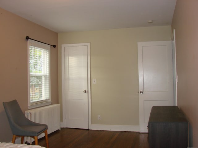 566 Savoy St, Bridgeport, CT 06606 - living area featuring radiator heating unit, dark wood finished floors, and baseboards