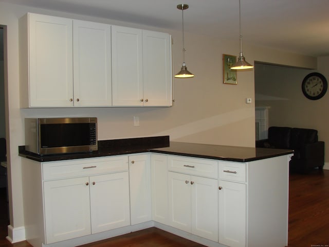 566 Savoy St, Bridgeport, CT 06606 - kitchen featuring stainless steel microwave, a peninsula, dark wood-style floors, and white cabinets