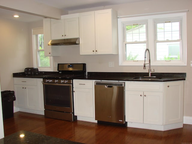 566 Savoy St, Bridgeport, CT 06606 - kitchen featuring stainless steel appliances, under cabinet range hood, a sink, dark wood-style floors, and beamed ceiling