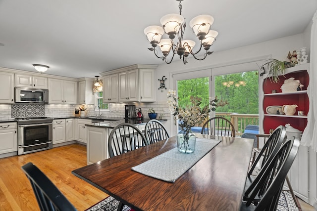 134 W Lake Ave, Guilford, CT 06437 - dining space featuring a chandelier, plenty of natural light, and light wood-style floors