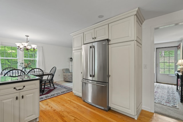 134 W Lake Ave, Guilford, CT 06437 - kitchen featuring stainless steel fridge, a chandelier, light wood finished floors, baseboards, and hanging light fixtures
