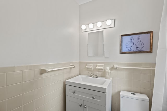 134 W Lake Ave, Guilford, CT 06437 - bathroom featuring toilet, vanity, wainscoting, and tile walls