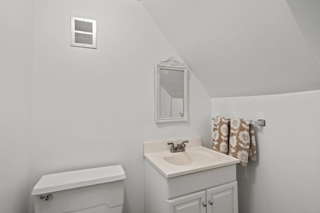 134 W Lake Ave, Guilford, CT 06437 - bathroom with lofted ceiling, toilet, and vanity