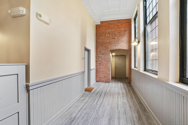 25 Grand St Apt 102, Norwalk, CT 06851 - corridor featuring plenty of natural light, wood finished floors, brick wall, wainscoting, and arched walkways