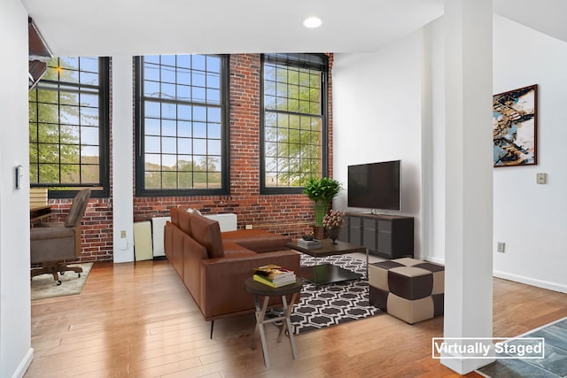 25 Grand St Apt 102, Norwalk, CT 06851 - living area featuring wood finished floors, baseboards, brick wall, and recessed lighting